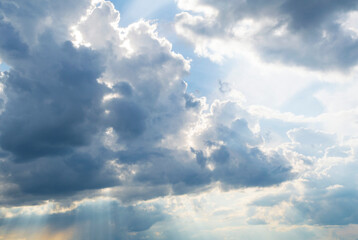 sky full of сumulonimbus clouds with long rays of the sun piercing them