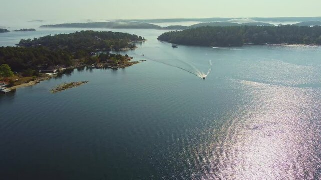 Small motorboats in the swedish archipelago near Stockholm, late summer, patchy fog, sunshine and idyllig landscape