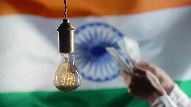 Glowing Edison light bulb on Indian flag background. Woman counting rupee INR money. Electricity price, bills, energy crisis, raising tariffs. 