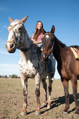 Chica joven montando a caballo en un rancho