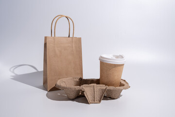 Paper cup and craft bag. A glass for coffee and hot drinks to take with you. Food delivery service. Paper bag close up. Blank space mockup for design, lettering or advertising