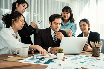 Diverse group of business analyst team analyzing financial data report paper on office table. Chart and graph dashboard by business intelligence analysis for strategic marketing planning Habiliment