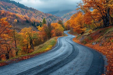 Naklejka premium Scenic autumn highway black asphalt road through colorful mountain landscape at sunset
