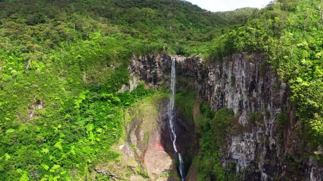 Picturesque flying over the mountain creek fall down from steep high cliff to wide green jungle valley. Cascade 500 Pieds waterfall also known as Cascade des Galets on Mauricius island in Indian ocean