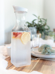 A carafe with infused water setting on a wedding table.