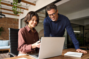 Two happy professional executives company team people working in corporate office using pc laptop...