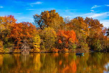 New york autumn. Autumn landscape. Fall nature. Rowboat on a small lake at the Central Park. Central Park Lake in autumn with people rowing boat. Central Park on sunny autumn day change colors. Scenic