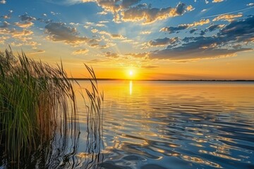 Idyllic sunset over a serene lake with rippling water and tall reeds