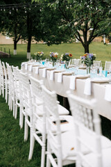 Photo of festive table in summer outdoor. Cozy vibe.