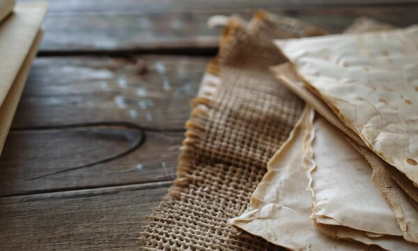 Vintage papers tied with string on a wooden table, evoking an old-fashioned, nostalgic atmosphere