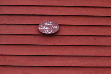 Sign with Swedish text. Red wooden background. Translated into leave your dishes here, please.