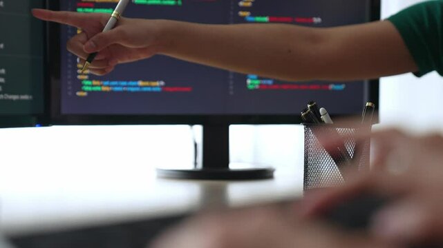 Slow motion back end software developer engineer for computer programming working together on debugging writing computing code, solving complex algorithms display on monitor in office. Burgeoning