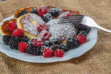 Cottage cheese pancakes with fresh raspberries, blackberries and powdered sugar