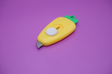 cute mini cutter with carrot shape. cute cutter isolated on purple background.