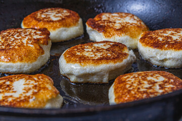 Cottage cheese pancakes are fried in a pan before being pulled out