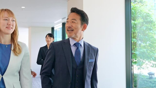 Group of multinational business people walking and talking inside a building