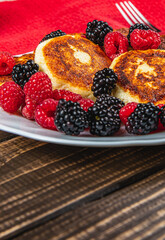 Fresh cottage cheese pancakes with raspberry blackberry on a white plate