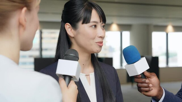 A woman being interviewed surrounded by reporters