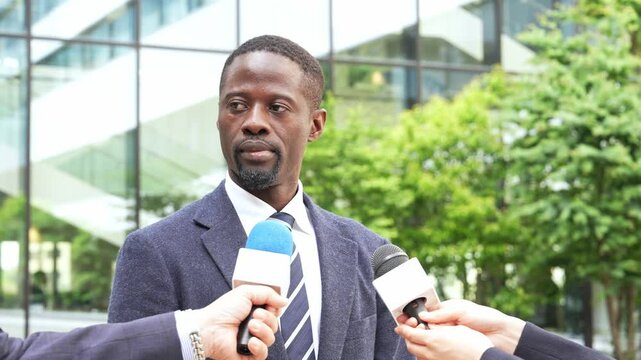 A black man being interviewed by reporters