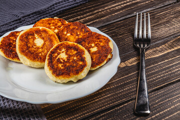 Fresh fried cottage cheese pancakes on a white plate