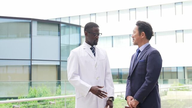 A foreign man and a businessman in a white coat having a conversation