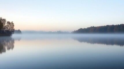 Obraz premium Drifting fog over a still lake at dawn, foggy weather, calm and ethereal