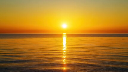 Obraz premium Golden sunset over a calm sea, clear weather, warm glow on the horizon