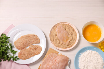 Making schnitzel. Slices of meat with bread crumbs and ingredients on white wooden table, flat lay