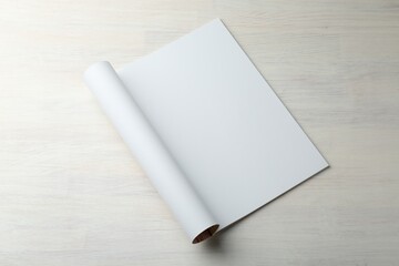 Open magazine with blank page on light wooden table. Mockup for design