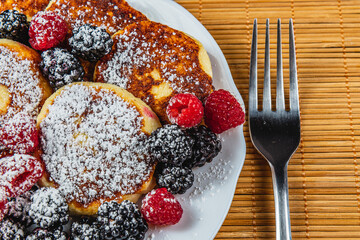 Cottage cheese pancakes with fresh raspberries, blackberries and powdered sugar