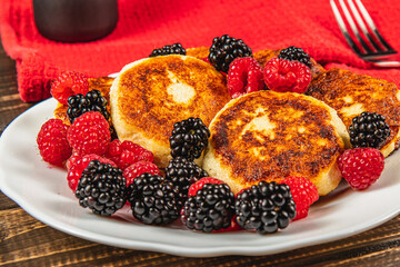 Fresh cottage cheese pancakes with raspberry blackberry on a white plate