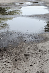 rain filled pot holes on road in winter