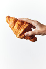 Hand holding a croissant on a white background