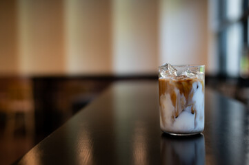 ice latte coffee in plastic glass on black table at cafe​