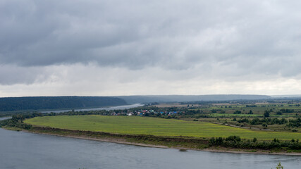 A cloudy day with a river and a field in the background