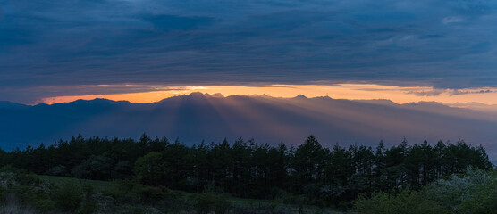 Obraz premium 日本 長野県岡谷市と塩尻市の境にある高ボッチ山の高ボッチ高原から見える夕陽の光芒と夕焼け空