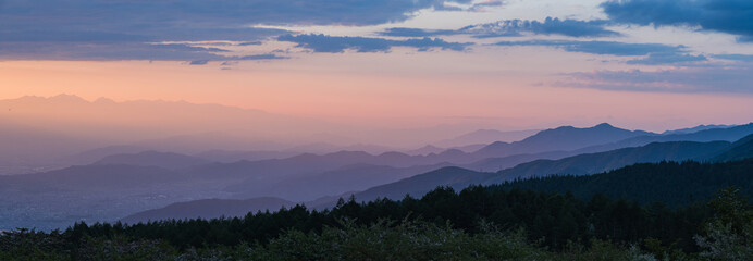 日本　長野県岡谷市と塩尻市の境にある高ボッチ山の高ボッチ高原から見える山のグラデーションと夕焼け空