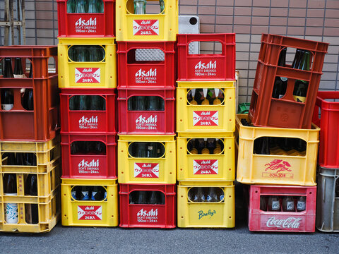TOKYO, JAPAN - September 4, 2024: Crates of empty glass bottles on a street by a restaurant in Tokyo's Yushima area.