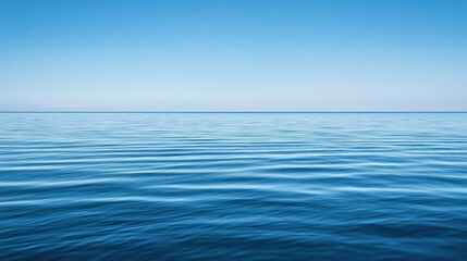 Calm blue water under the clear summer sky, with soft reflections creating a soothing, peaceful background.