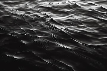 Obraz premium A stunning close-up view of dark water textures, showcasing mesmerizing ripples and reflections in an artistic black and white style.