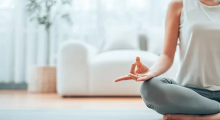 Fototapete Close up hand of Asian woman practicing yoga and meditation at home sitting on floor in living room in lotus position. Mindful meditation and wellbeing concept © Monster Ztudio