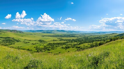 Obraz premium Scenic Mountain Valley Landscape with Lush Green Grass Blue Sky and Clouds