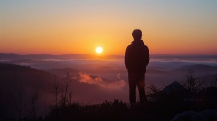 Obraz premium Breathtaking Mountain Sunrise: A Serene Silhouette Overlooking the Horizon