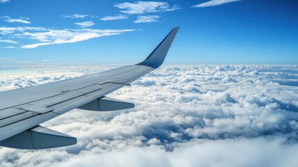 A close-up of an airplane wing with the clouds below