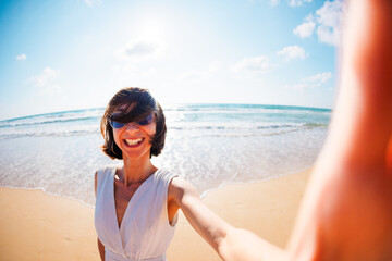 Photo of a cute surprised excited young beautiful girl walking on the beach and taking a selfie to the camera.