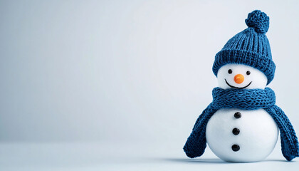 Cheerful snowman wearing a blue hat and scarf, standing against a light background, perfect for winter and holiday themes.