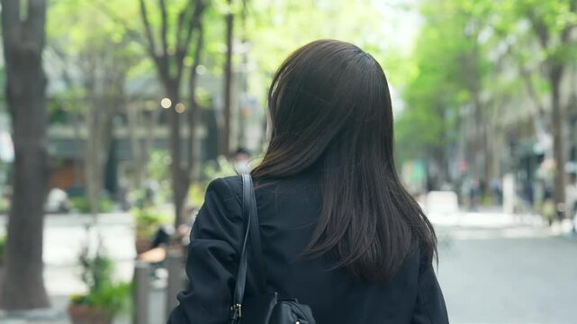 街を歩く女性ビジネスパーソンの後ろ姿