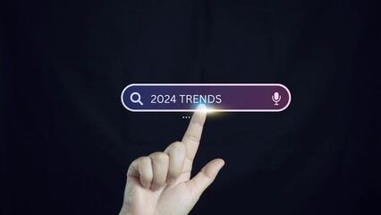 business planing in new year concept.Businessman touching to search engine bar with 2024 trends wording for marketing monitor.