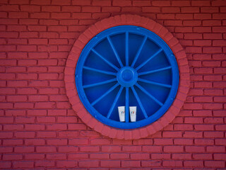 White Cups within a Blue Wheel against Red Brick