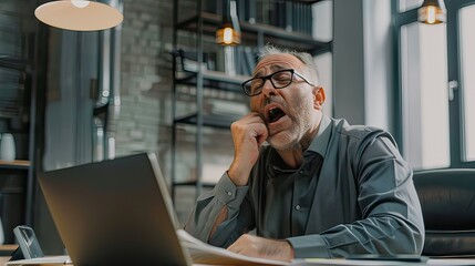 Weary middle-aged white man yawning while taking notes in a dull business meeting. 